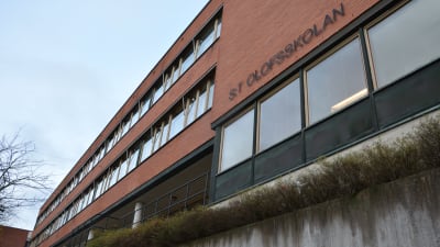 Bild på S:t Olofsskolans tegelbyggnad utifrån, skolans namn står på väggen.