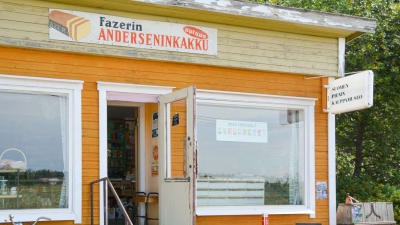 Finlands minsta butiksmuseum från utsidan. På bilden syns ett gammalt gult slitet trähus från 1958.