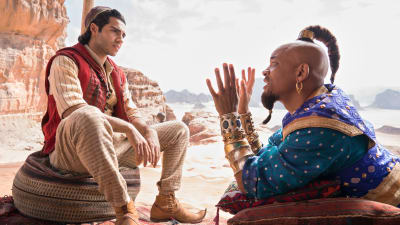 Aladdin (Mena Massoud) lyssnar då anden i flaskan (Will Smith) talar.