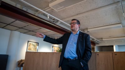 Veli-Pekka Säikkälä berättar något med handen.