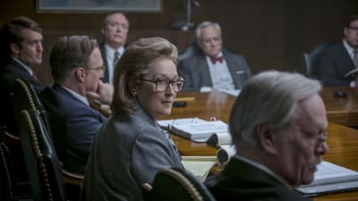 Närbild på Katharine Graham (Meryl Streep) i ett konferensrum fyllt av män.