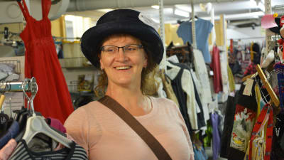 Kvinna på en loppmarknad iklädd en rolig hatt.