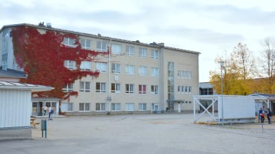 Sarlinska skolas byggnad i halvmulet höstväder. En vit tegelbyggnad med fyra våningar.