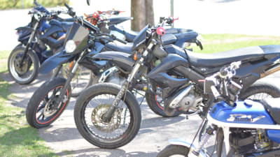 Mopeder parkerade i en rad.De råkar alla vara blå.