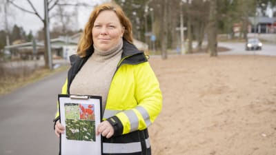 Raseborgs ansvariga parkchef Maria Eriksson poserar vid en väg med en bild i handen. 