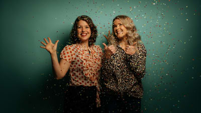 Två leende kvinnor i konfettiregn