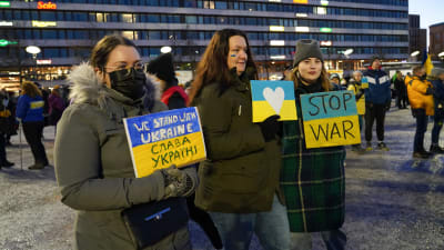Tre unga kvinnor håller i skyltar i stöd för Ukraina på Vasa torg.