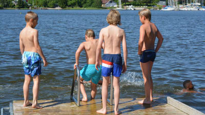 Barn på brygga vid badstrand