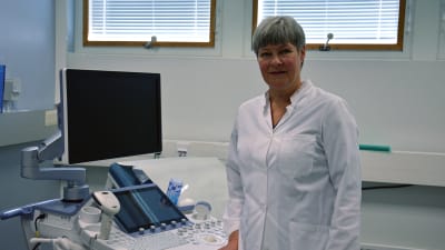 Kvinna står vid en ultraljudsmaskin i ett sjukhus.