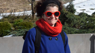 kvinna i röda solglasön och blå kappa