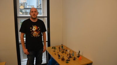 En man står framför ett bord med spelfigurer.