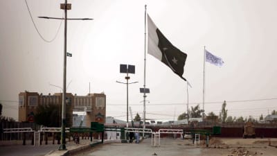 Den här bilden på gränsövergången Spin Boldak är tagen från den pakistanska sidan om gränsen. I bakgrunden, på den afghanska sidan, syns talibanernas vita flagga. Flaggan pryds av den muslimska trosbekännelsen. 