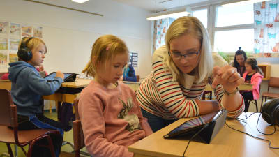 Lärare Camilla Willberg i Yttermalax skola instruerar Alwa Kinnunen i hur man använder pekplattan