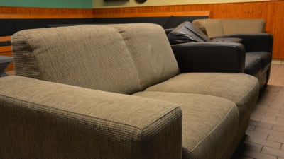 En ljusgrå och svart soffa i en föreningslokal. 