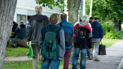 Flera personer står i kö.
