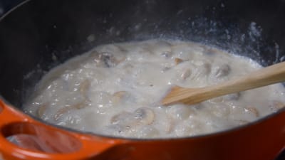 Getmjölksstuvad kål med svamp i en kastrull
