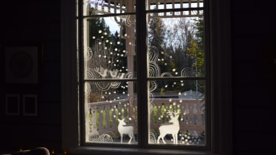 Fönster dekorerat med ritade vita mönster och bilder.