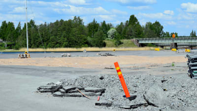 En sandgrop och en varningsstolpe i Norra hamnen i Ekenäs där hamnmagasinet stod tidigare. Hav i bakgrunden. En vacker sommardag.