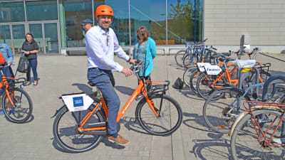 Man på orange cykel.
