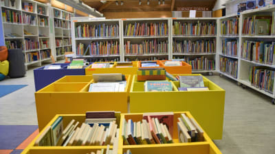 Hyllor med lådor och böcker i ett bibliotek.