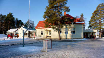 Skolgård med ishockeymål och basketkorg.