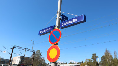 Skyltar där det står Kauniainen och Grankulla. 