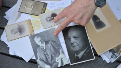 Fotografier på bland andra Jean Sibelius och Henrik Mattsson ligger utspridda på ett bord utomhus.