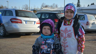 En pojke och en flicka utklädda till påskhäxor.
