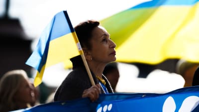 En kvinna håller i en ukrainska flagga.