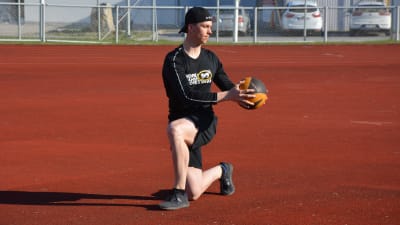 Joel Blomqvist står på knä och tränar styrka med en boll