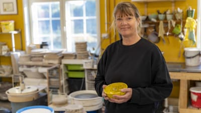 Kvinna med en gul skål i handen.