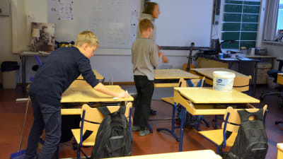 Eleverna städar upp i klassen efter slöjdlektionen.