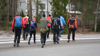 Joggare i färggranna kläder promenerar iväg med raska steg.