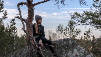 Mathilda Sjöblom sitter på ett berg.