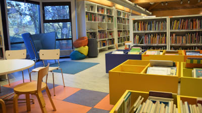 Hyllor med lådor och böcker i ett bibliotek.