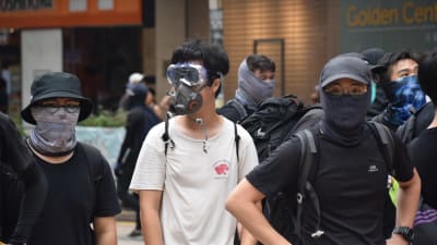 Demonstranterna använder masker dels för att skydda sig och dels för att dölja sin identitet. Hårda straff väntar dem som blir dömda för att ha deltagit i upplopp.