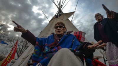 Kvinna sitter framför en tipi