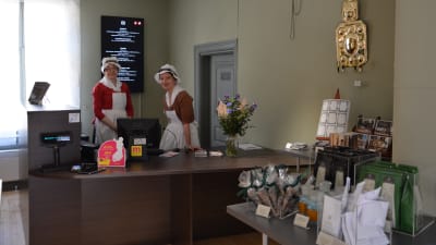 Två kvinnor bakom en disk.