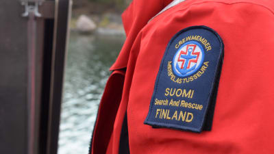 Bild på en arm med en lapp på armen med sjöräddningssällskapets logo och text.