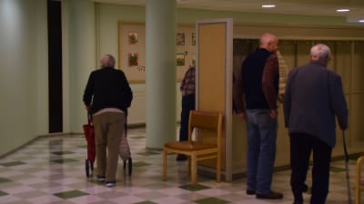 Äldre personer går i en korridor på dagverksamheten i Ekenäs.