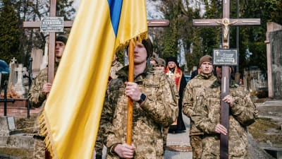 Soldater följer sina fallna kamraters kistor till en begravningsplats i Lviv.