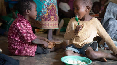 två afrikanska barn äter gröt