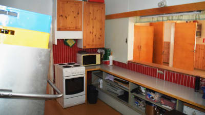 En bild på ett kök i 60-talsstil med röda väggar och furu. 