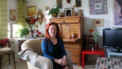 Lena Bengtson sitter i en fåtölj i sitt vardagsrum och ser bestämd ut.