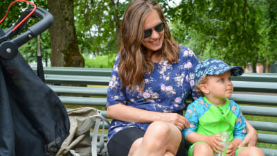 Emma Lavonen med sitt barn Aaron Lavonen på en bänk i en park. 