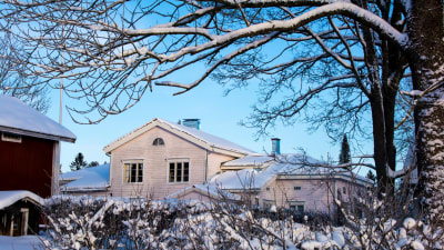 Gammal gårdsbyggnad i vinterskrud.