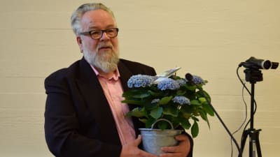 Veijo Lücke med blommor i famnen.