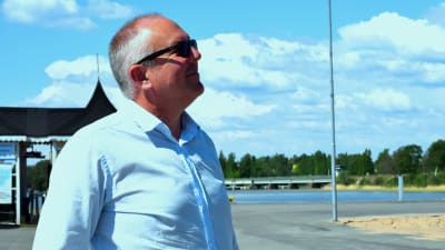 Företagare Tom Nylund i profil en solig sommardag i Norra hamnen i Ekenäs. Hav i bakgrunden.