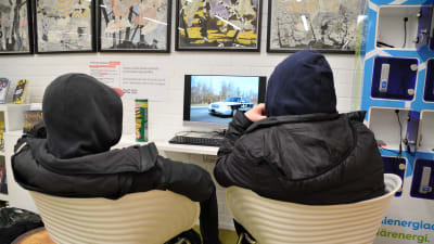 Två pojkar som tittar på en datorskärm.