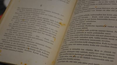 En bok som är uppslagen har många gulbruna fläckar, så den är avskriven 